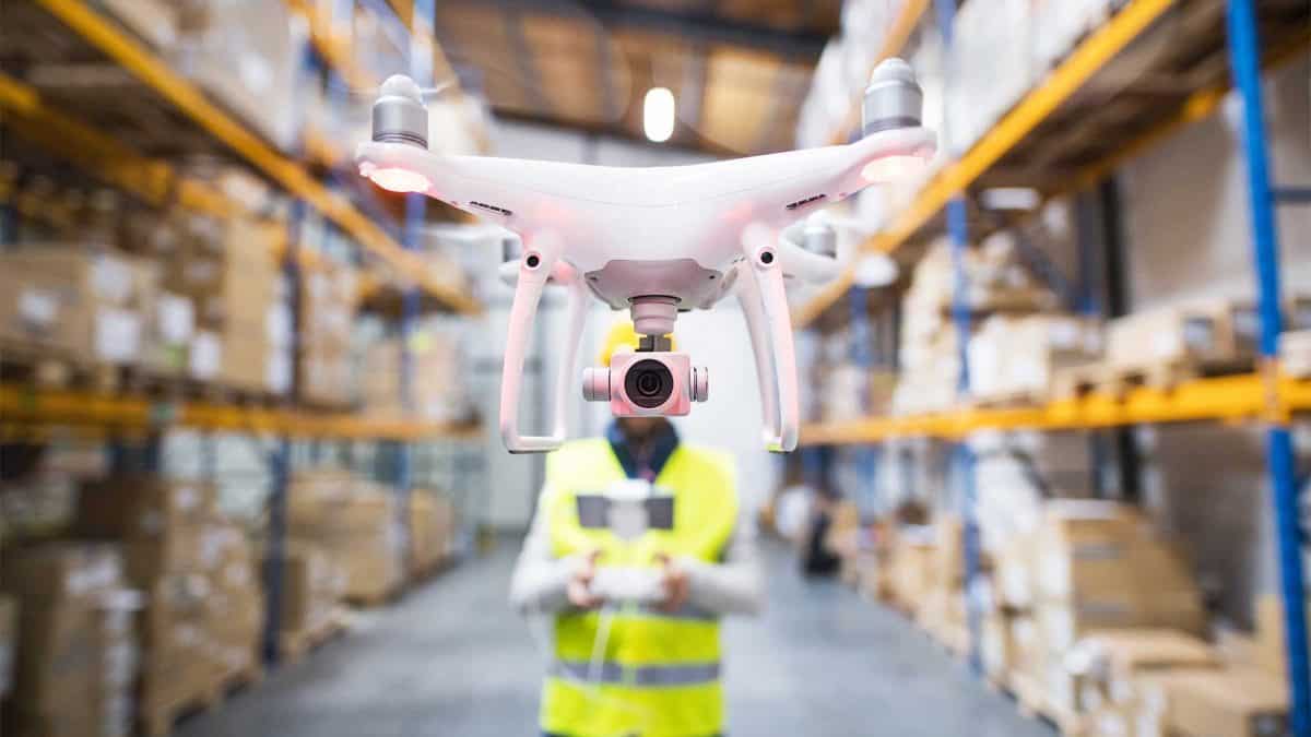Un piloto de dron graba un vídeo corporativo en una nave industrial