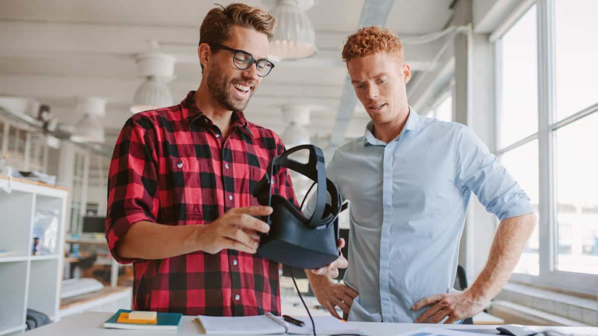 Dos técnicos jóvenes preparan su visor de realidad virtual para ver un vídeo 360 en 3D.