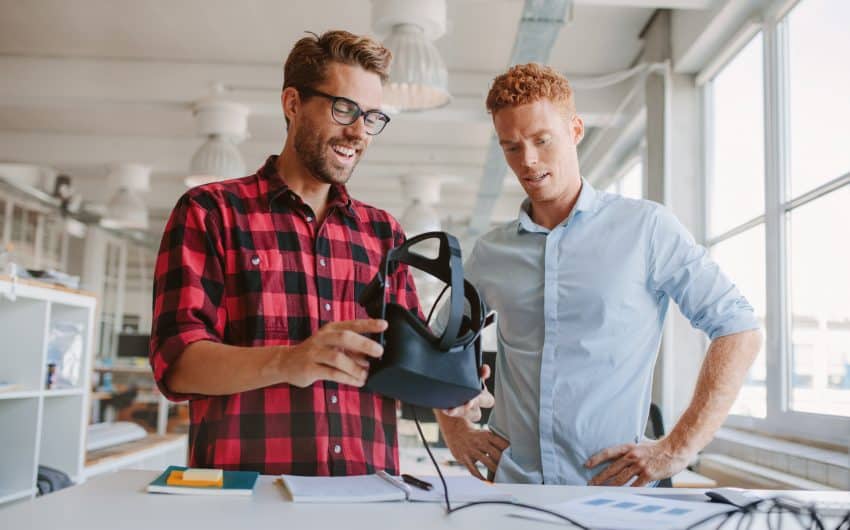Dos técnicos jóvenes preparan su visor de realidad virtual para ver un vídeo 360 en 3D.
