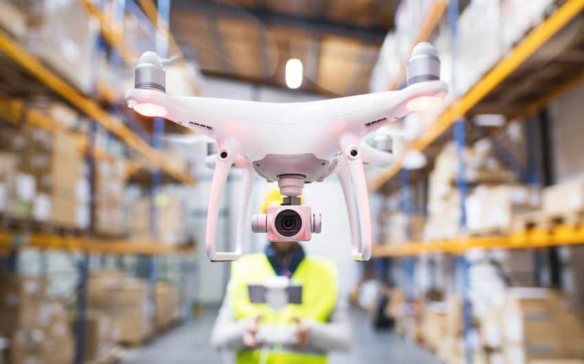 Un piloto de dron graba un vídeo corporativo en una nave industrial